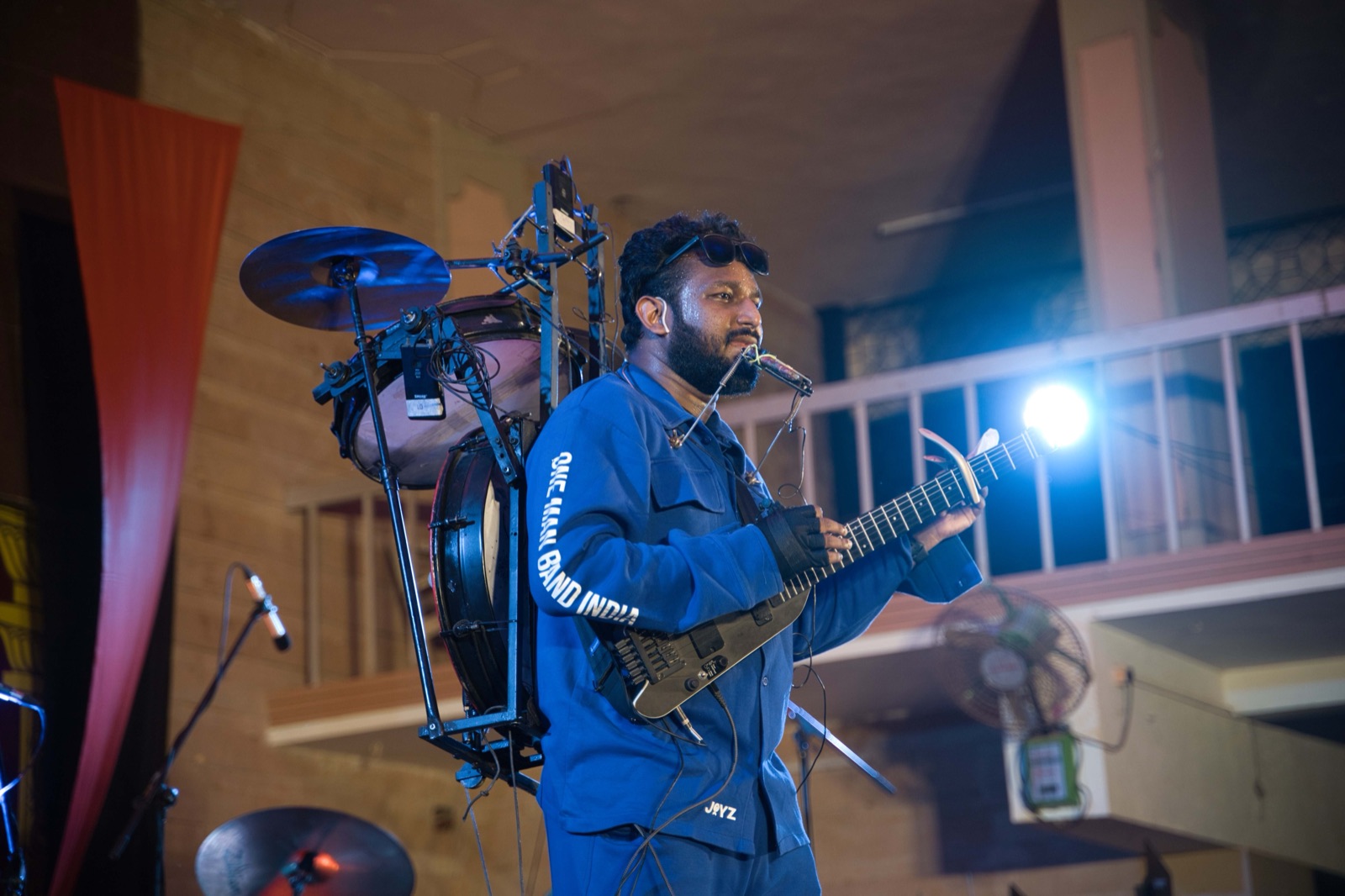 Gladson Peter on stage in One Man Band India colours, full rig on his back