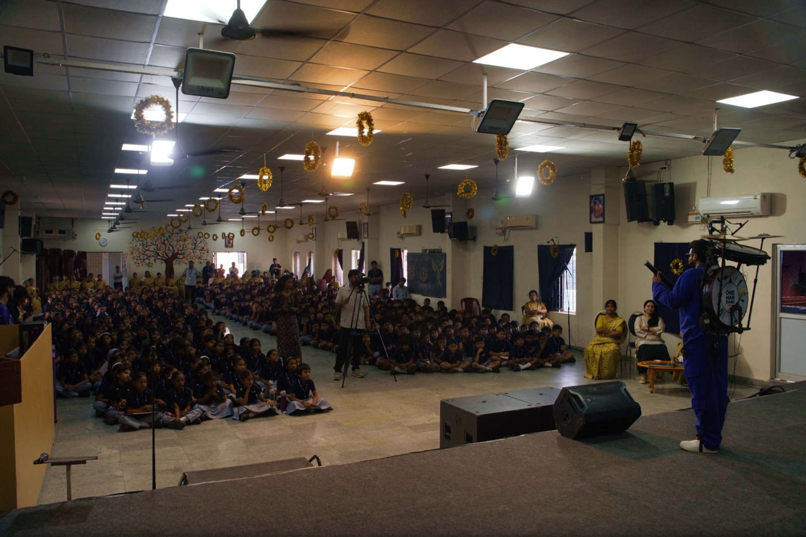 Gladson Peter addressing a packed school hall with the rig on stage